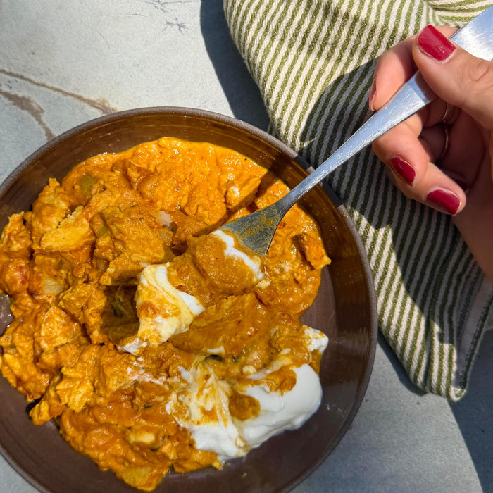 Creamy chicken curry with yogurt, served in a bowl with a fork, ready to eat