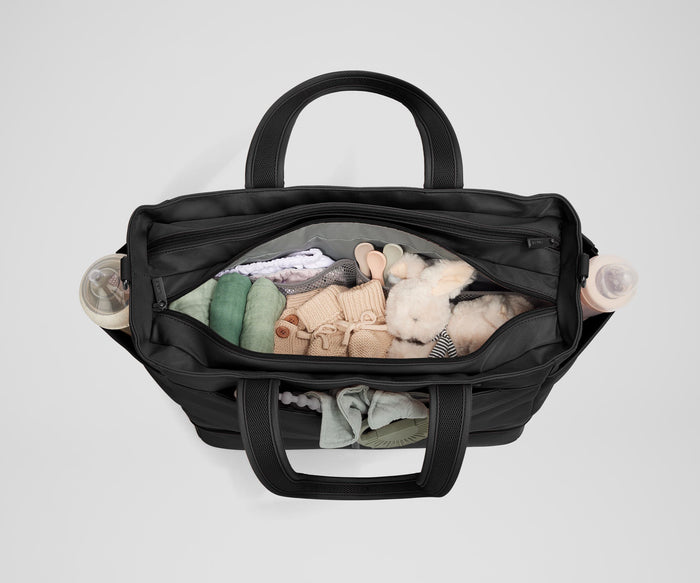Front main compartment packed with child essentials, including a stuffed animal, wipes, and change of clothes