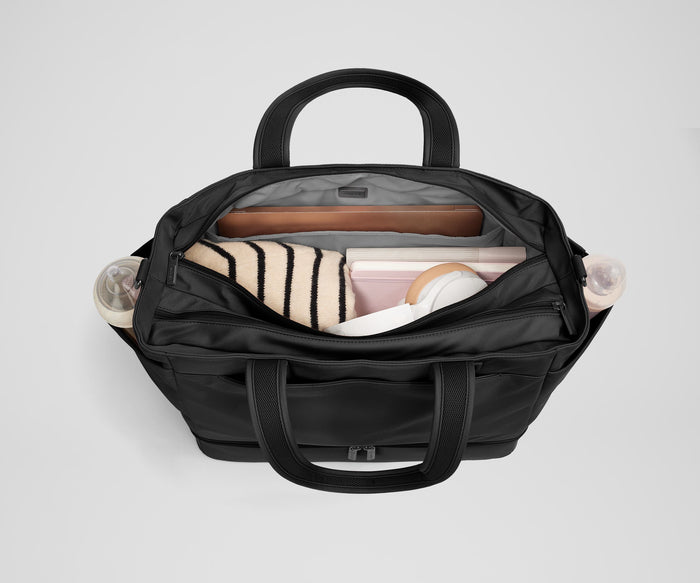 Back main compartment packed with adult travel essentials, including a laptop, notebook, and extra clothes
