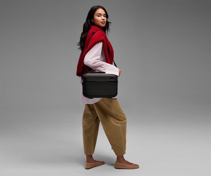 Person wearing the Train Case on their shoulder using the detachable shoulder strap
// Model is 5’9”